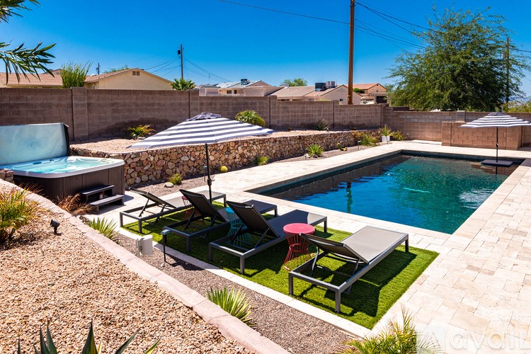 A pool with a hot tub and a table with chairs.