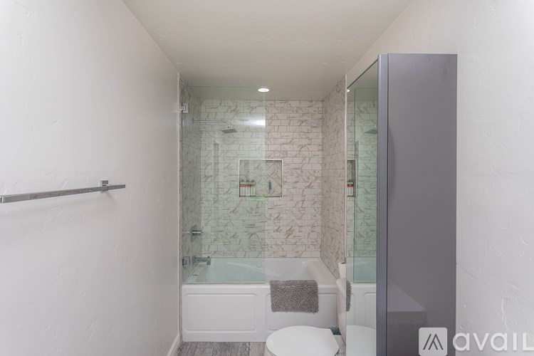 A bathroom with a glass shower door and a white toilet.