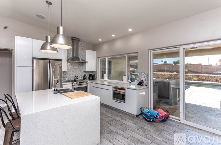 A modern kitchen with a large island and a view of the backyard.