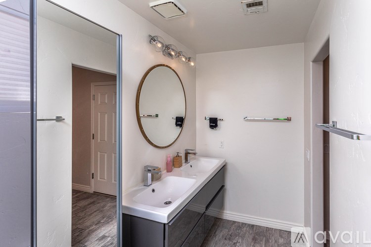 A bathroom with a round mirror and a sink.