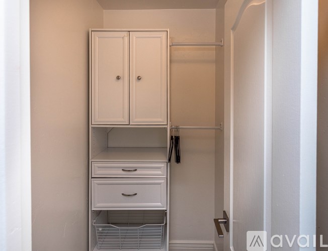 A white closet with a coat hanging on the rod.