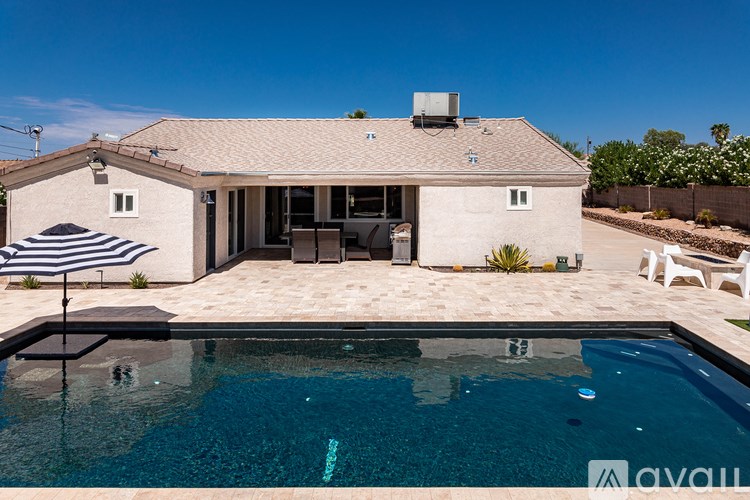 A house with a pool in front of it.