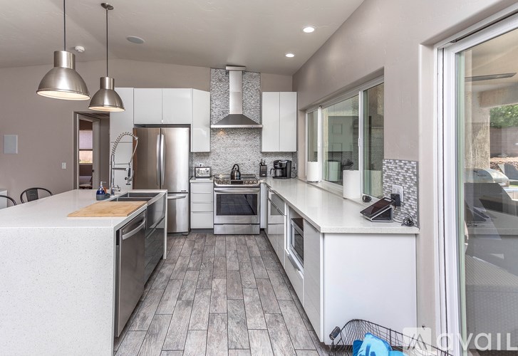 A modern kitchen with stainless steel appliances and white cabinetry.