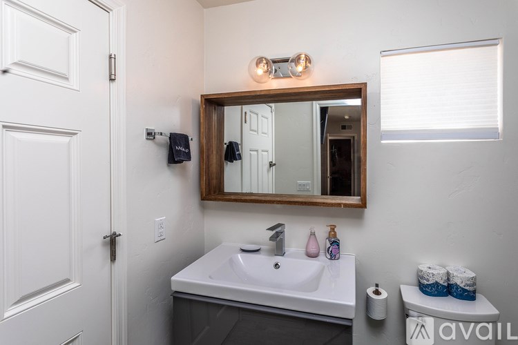 A bathroom with a white sink and a mirror above it.