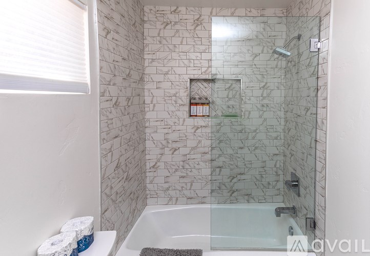 A bathroom with a glass shower door and a glass tub.