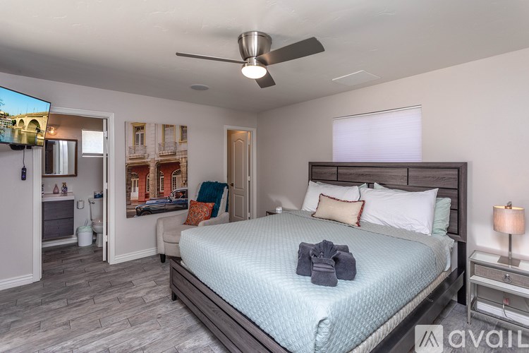 A bedroom with a bed, nightstand, and a ceiling fan.