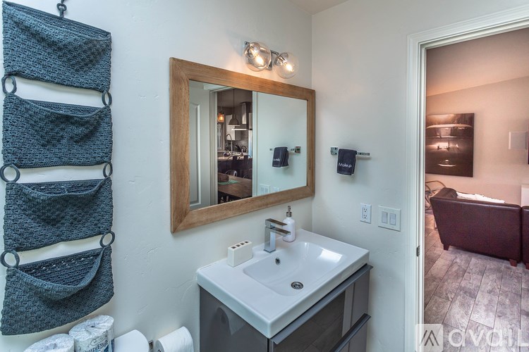 A bathroom with a white sink and a mirror above it.