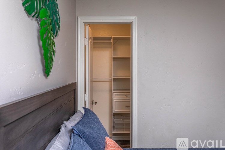 A bedroom with a bed and a green leaf decoration on the wall.