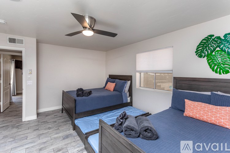 A bedroom with a bed, a ceiling fan, and a window.