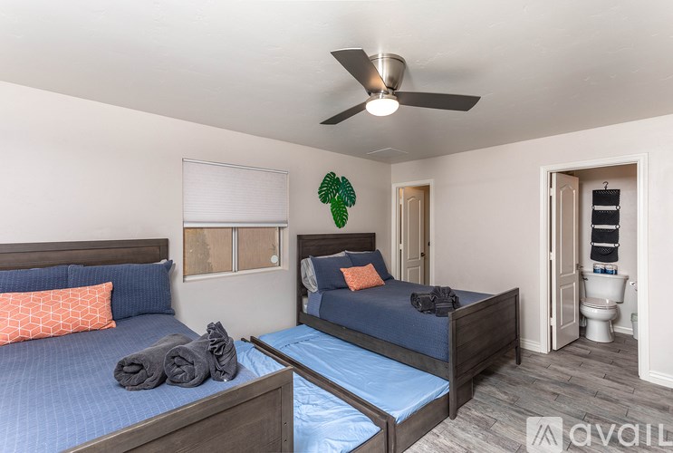 A bedroom with two beds and a ceiling fan.