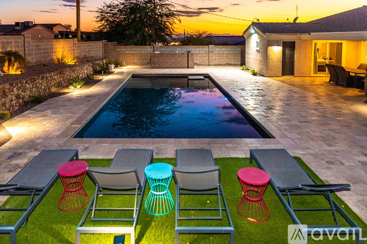 A pool surrounded by four chairs and a table.