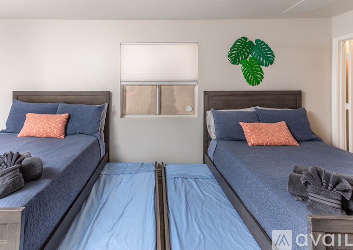 Two twin beds with blue bedspreads and pillows in a room.