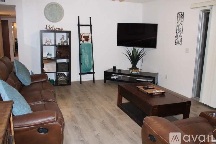 A living room with a brown leather couch and a wooden coffee table.