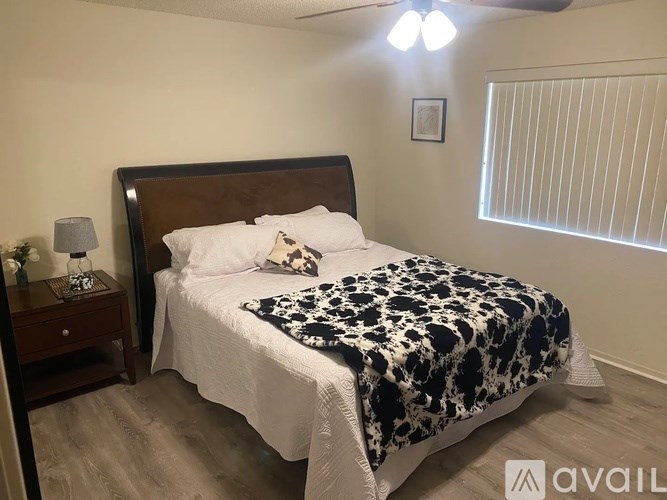 A bedroom with a bed, nightstand, and window.