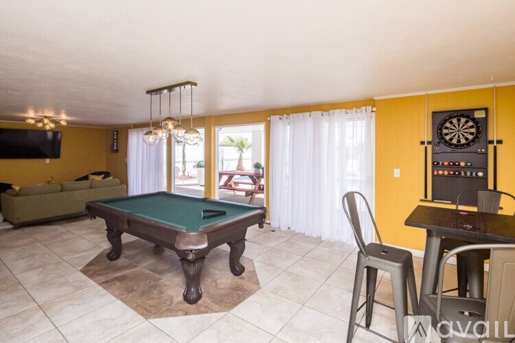 A room with a pool table and a dartboard.