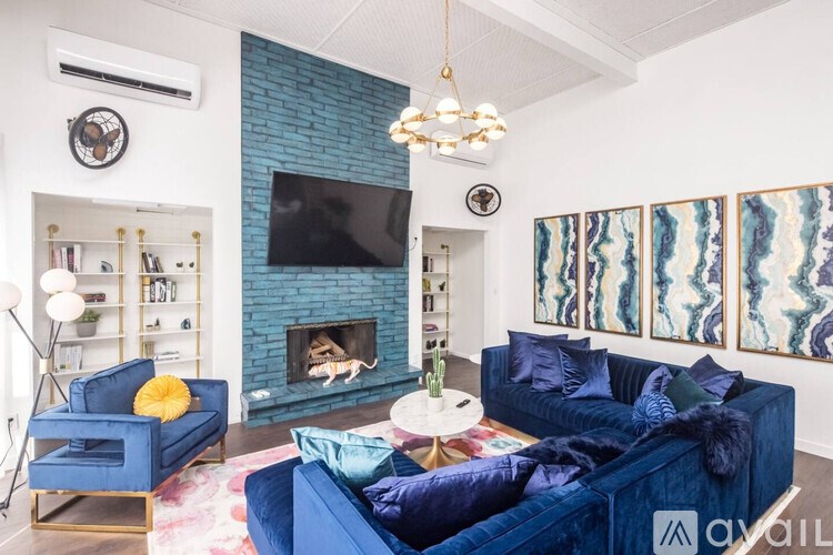 A living room with a blue couch and a fireplace.