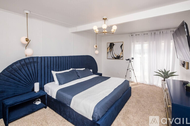 A bedroom with a large bed and a blue headboard.