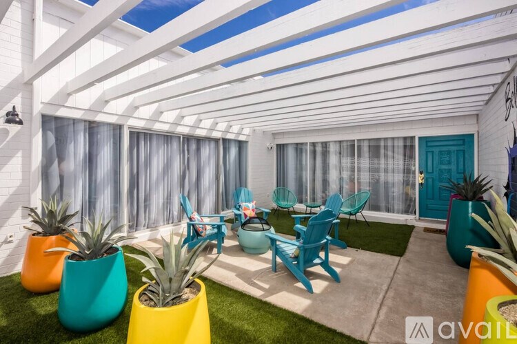 A patio with a table and chairs under a white pergola.