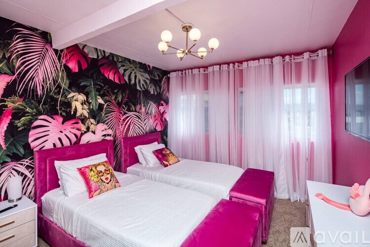 A bedroom with a white bed and pink accents.