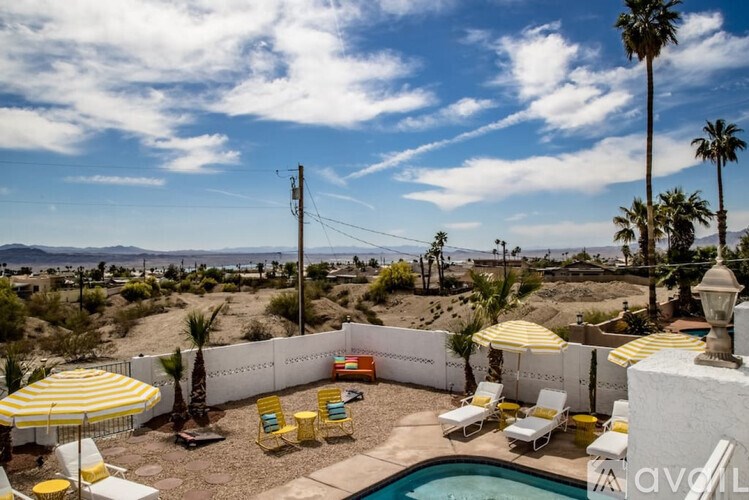 A pool area with yellow and white striped umbrellas.