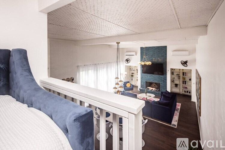 A bedroom with a white bed and blue chairs.