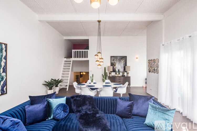 A blue couch with a black dog on it in a living room.