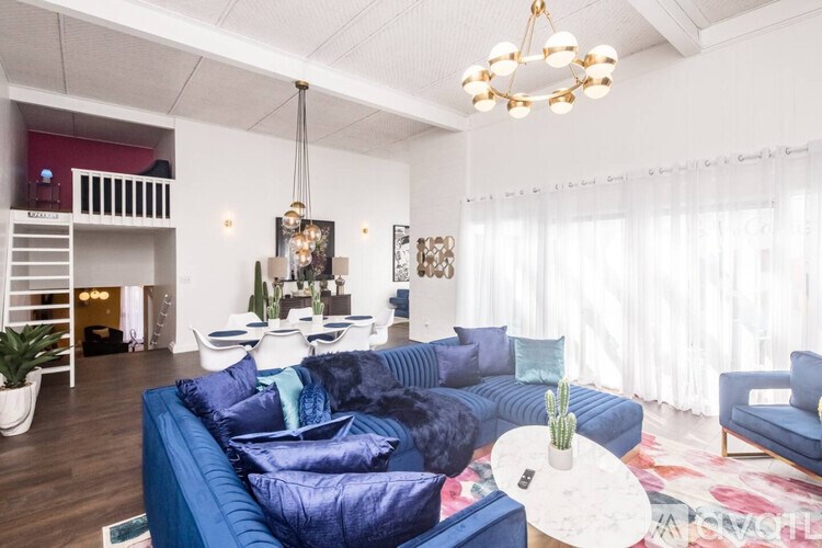 A living room with a blue couch and a white coffee table.