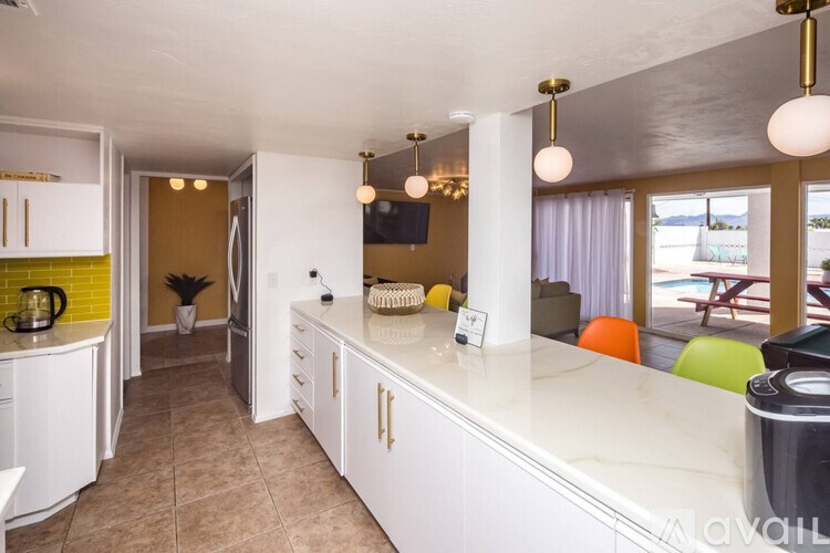A kitchen with white cabinets and a countertop with a coffee maker on it.