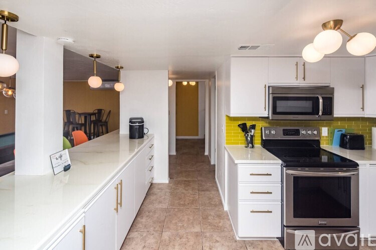 A kitchen with white cabinets and a black stove top oven.