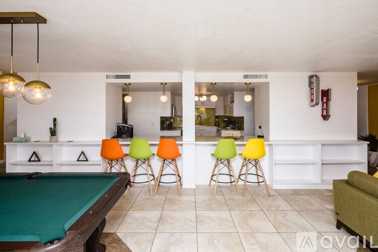 A room with a pool table and bar area.