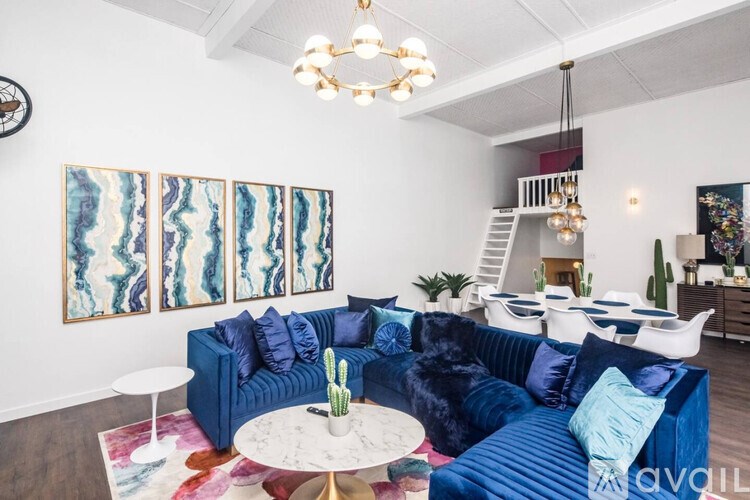 A living room with a blue couch and a white coffee table.
