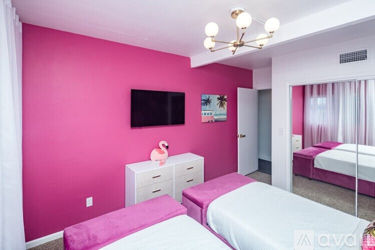A pink bedroom with a pink flamingo decoration on the dresser.