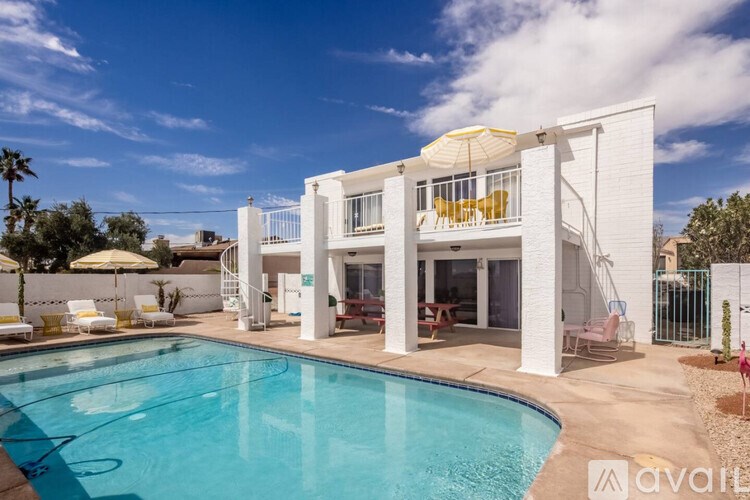 A white house with a pool in the backyard.