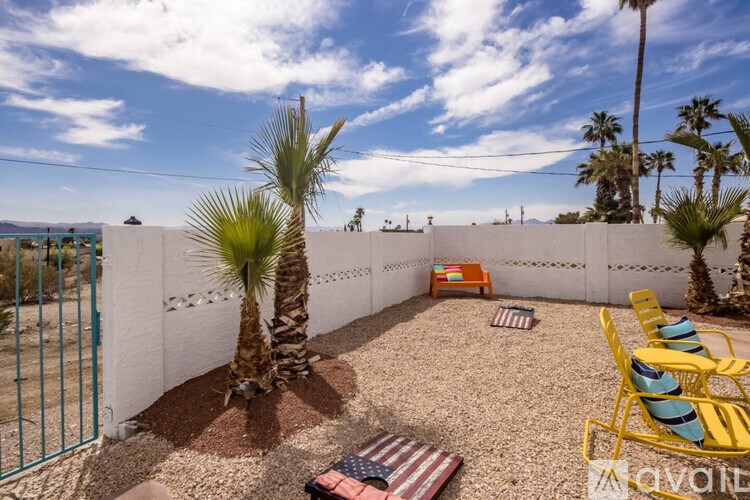 A patio with a palm tree and chairs.