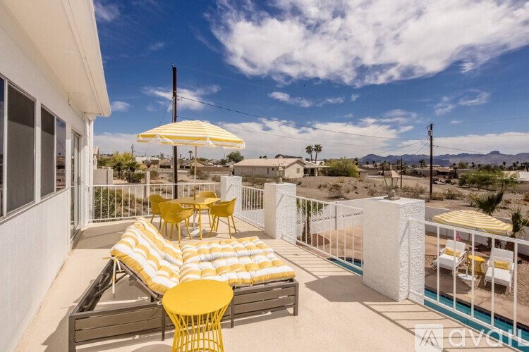 A sunny patio with yellow chairs and a table.
