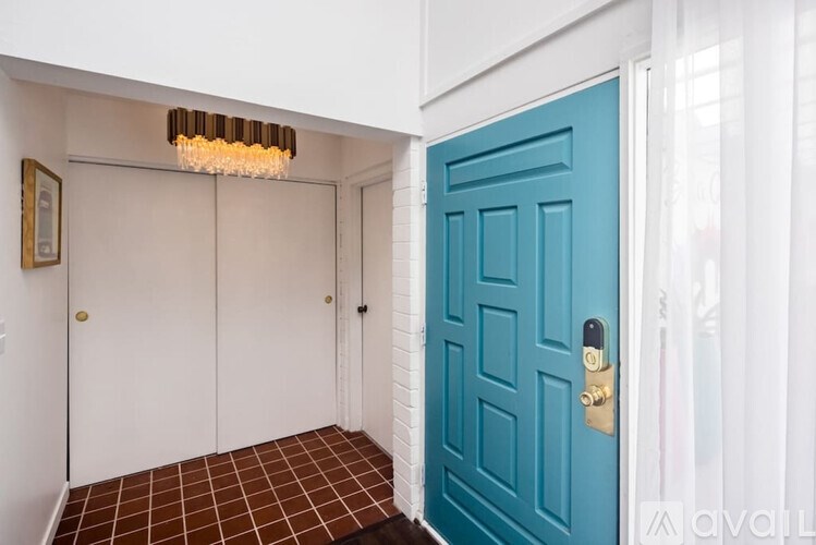 A blue door is in a white hallway.
