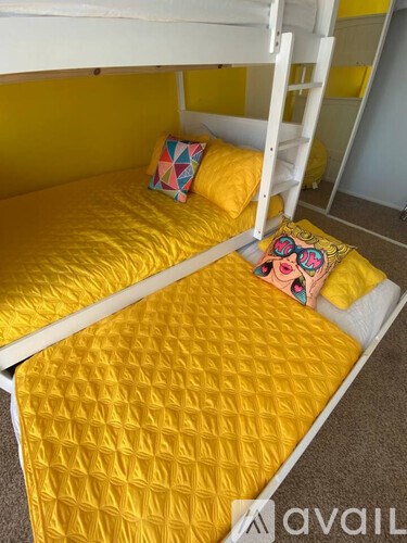 Two beds with yellow bedspreads and pillows.