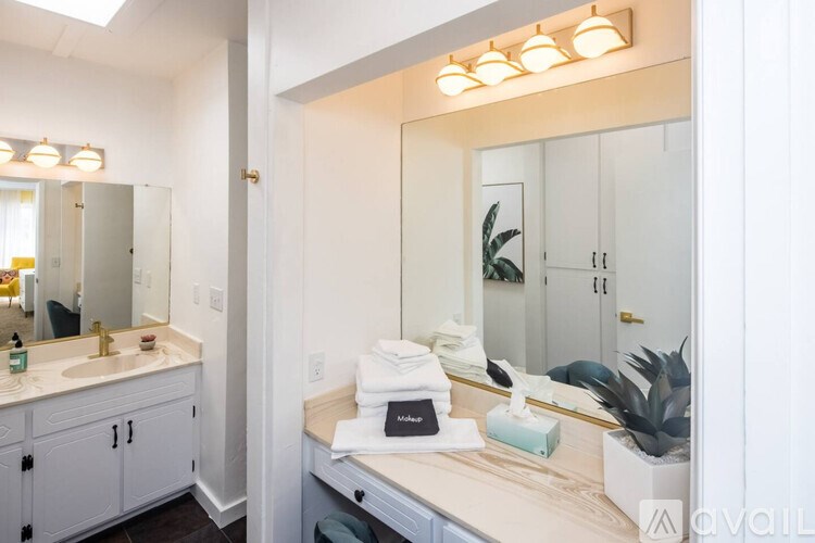 A bathroom with a sink, mirror, and towel.