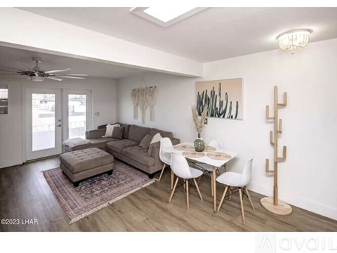 A living room with a couch, chairs, and a table with a vase on it.