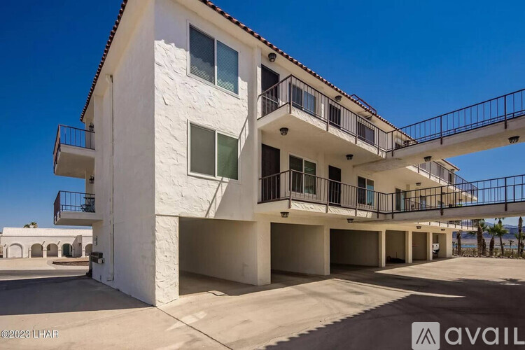 A white building with a balcony and a sign that says "available".