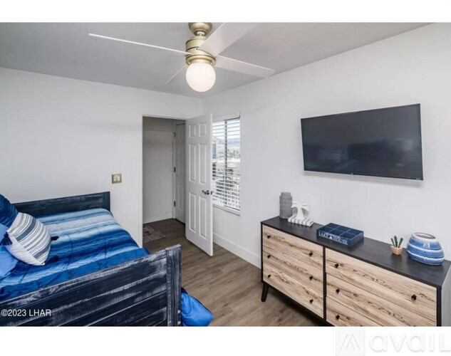 A bedroom with a bed, dresser, and television.