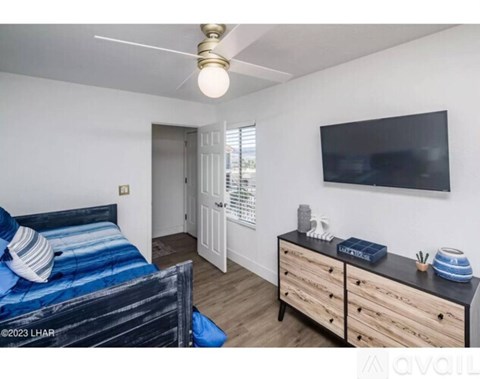 A bedroom with a bed, dresser, and television.