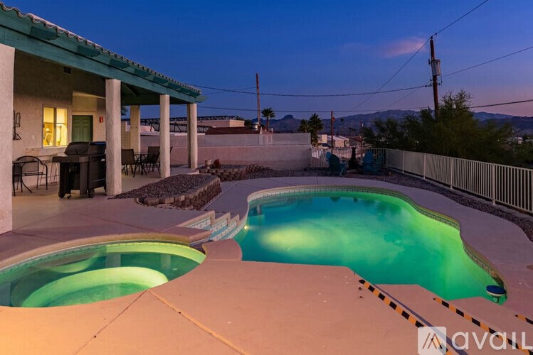 A pool with a hot tub on the side of a house.