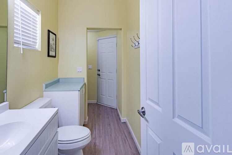 A bathroom with a toilet, sink, and a door.
