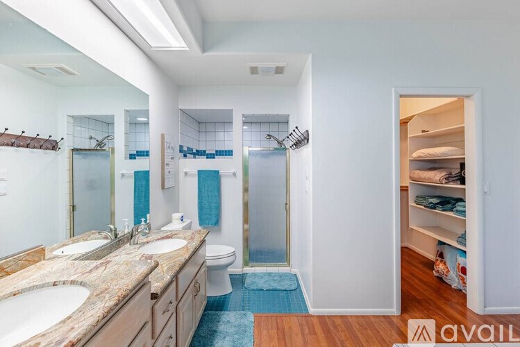 A bathroom with a marble countertop and a walk-in shower.