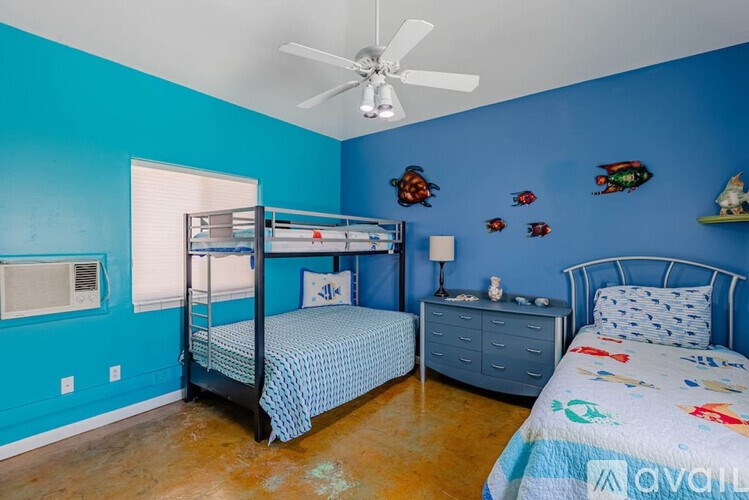 A room with two beds and a ceiling fan.