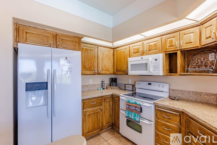 A kitchen with wooden cabinets and a white fridge.