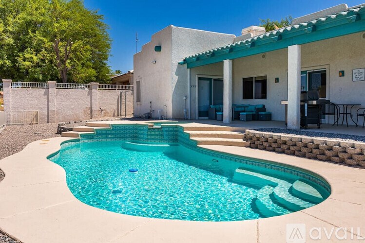 A pool in a backyard with a house in the background.