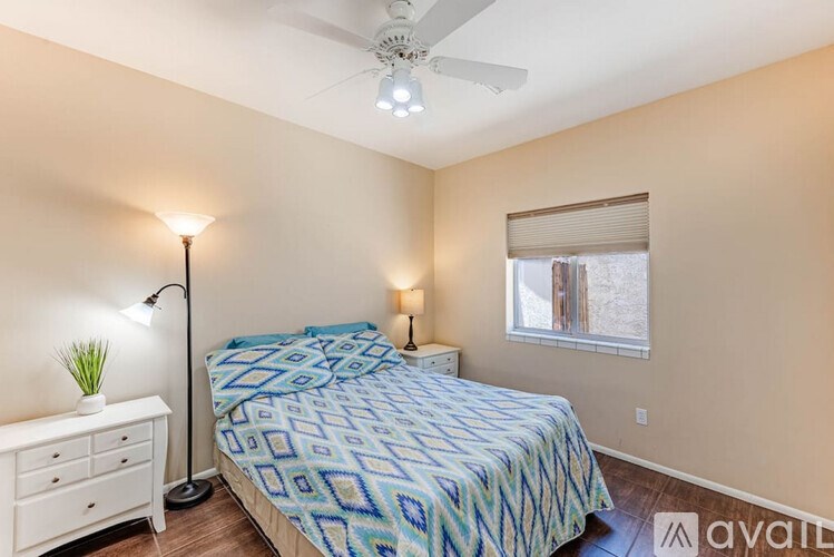 A bedroom with a bed, nightstand, and window.