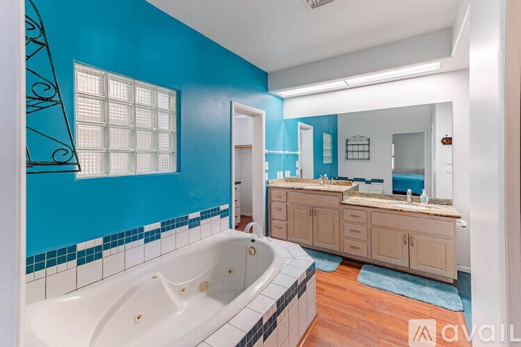 A bathroom with blue walls and a white bathtub.
